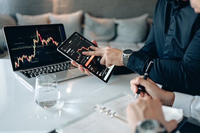 Two people sitting at a table examining digital charts.